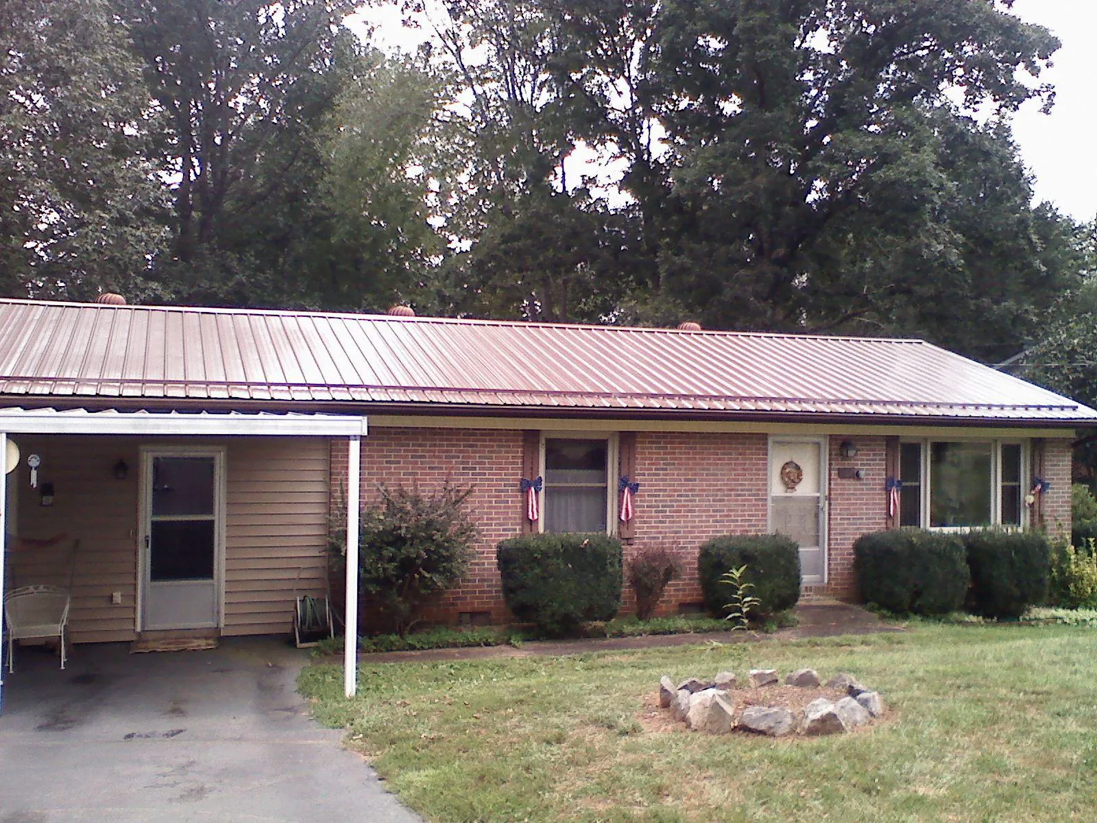 Bronze metal roof and carport on a brick ranch home — Roof Repair work by our crew in Fremont